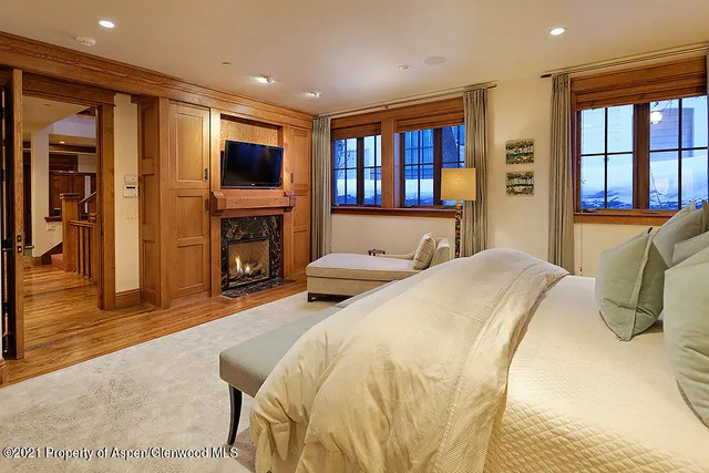 a spacious bedroom with a bed and a flat screen tv