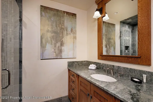 a bathroom with a granite countertop sink and a mirror
