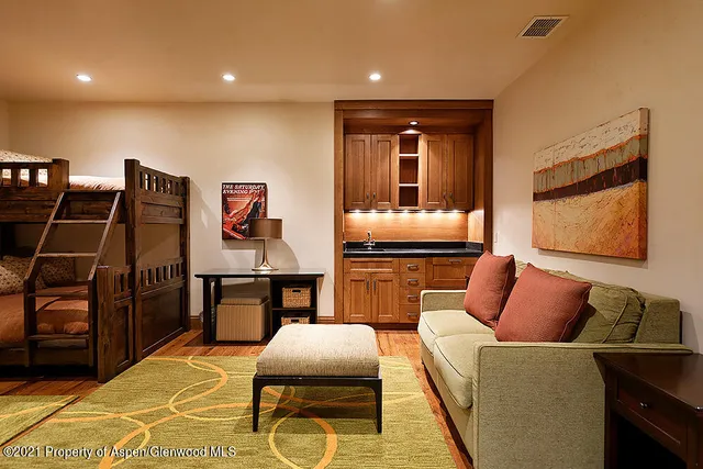 a living room with furniture a rug and kitchen view