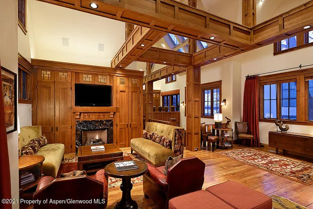 a living room with furniture a flat screen tv and kitchen view