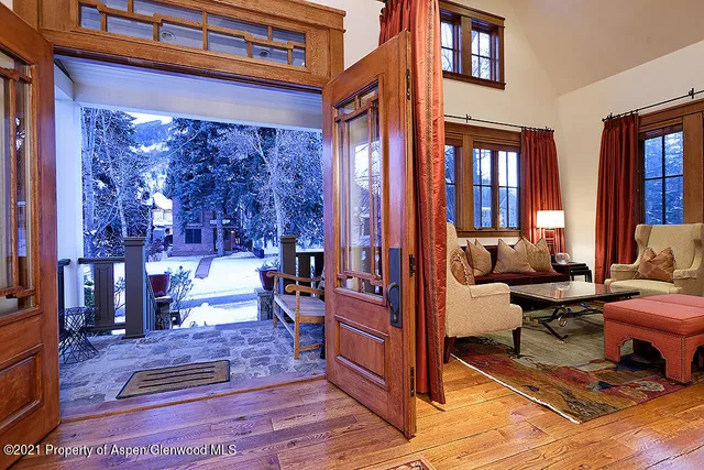 a living room with furniture a rug and a floor to ceiling window