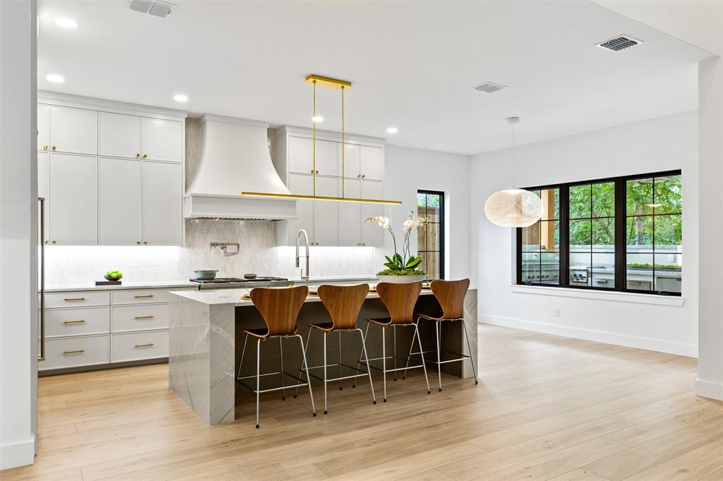6446 Lange Circle Dallas, TX 75214 - Photo 8 of 40 a kitchen with stainless steel appliances granite countertop a stove a sink a oven a dining table and chairs with wooden floor