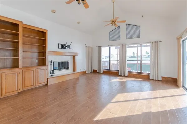 a view of an empty room with a fireplace and a window
