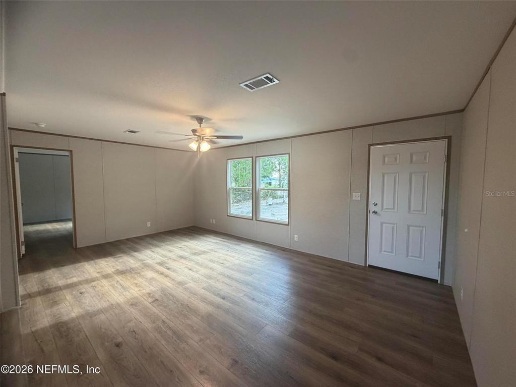 114 Nutmeg Trail Interlachen, FL 32148 - Photo 7 of 33 an empty room with wooden floor cabinet and windows