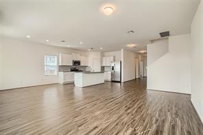 700 Mallow Road Leander, TX 78641 - Photo 6 of 28 Polished flooring stretches across a vast open-plan layout connecting the living area and kitchen.