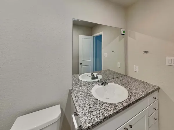 a bathroom with a granite countertop sink a toilet and shower