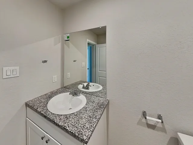 a bathroom with a granite countertop sink and a mirror