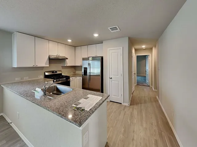 a kitchen with stainless steel appliances granite countertop a refrigerator sink and cabinets