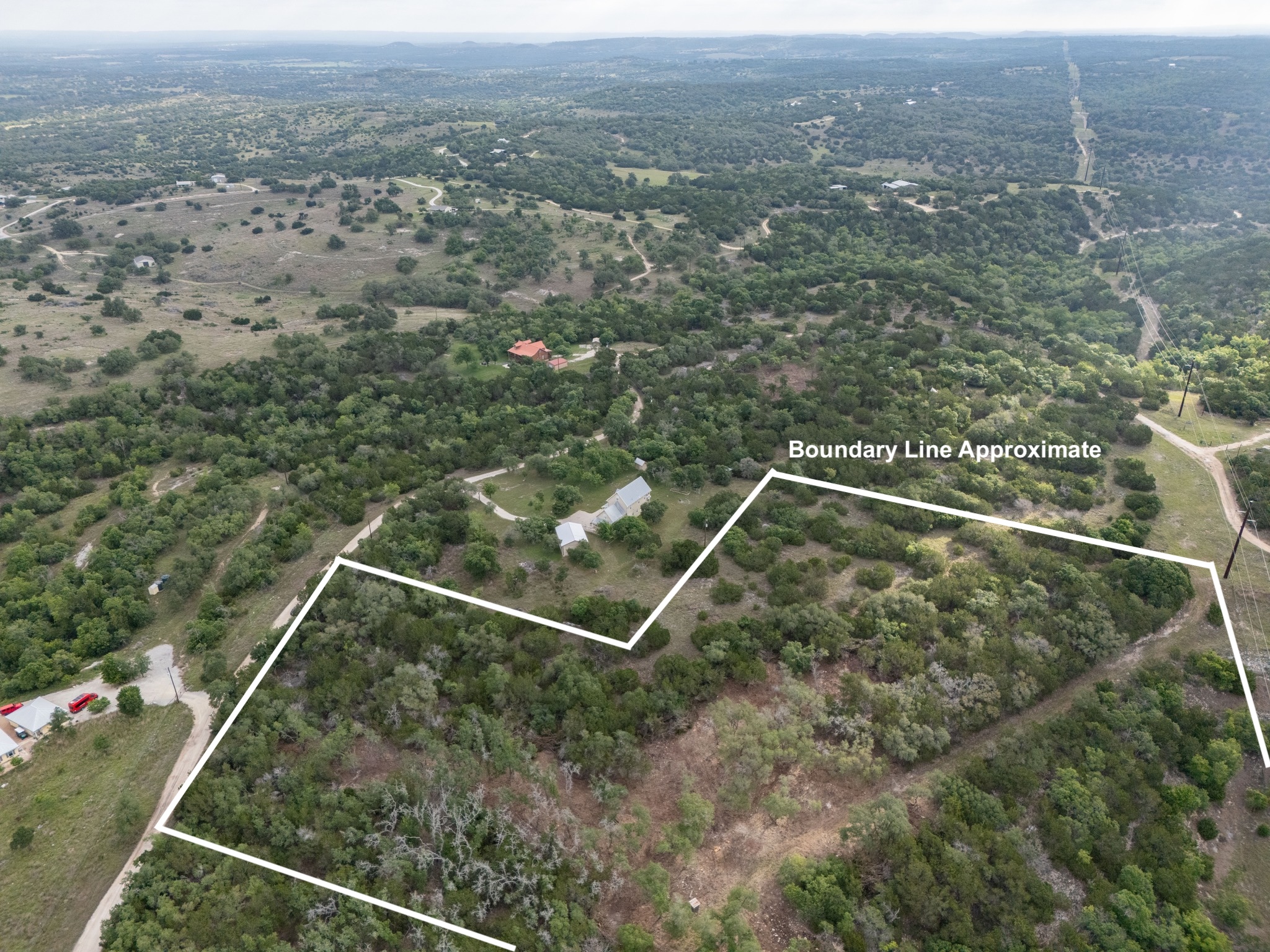 A vast countryside landscape showcases rolling hills, dense native trees, and sweeping long-range horizons.