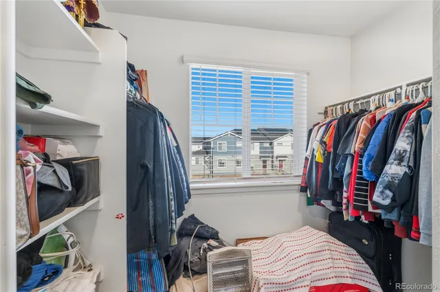 a view of walk in closet with clothes and shoes