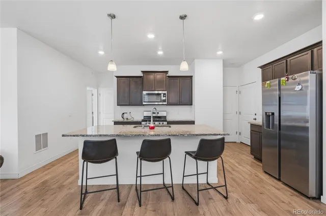 a kitchen with kitchen island wooden cabinets and stainless steel appliances