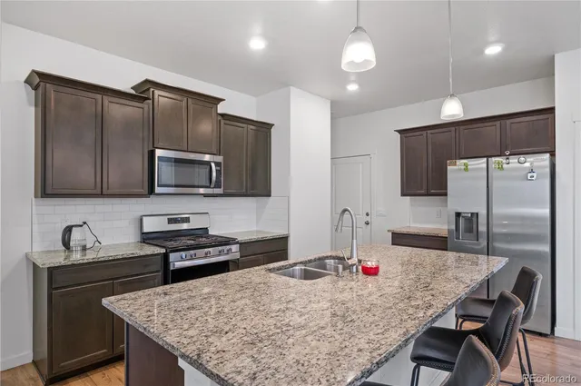 a kitchen with granite countertop a sink appliances and cabinets