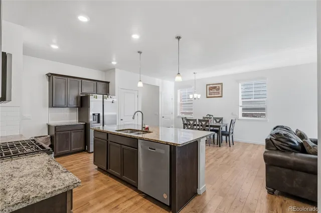 a kitchen with stainless steel appliances granite countertop a sink a stove and a refrigerator