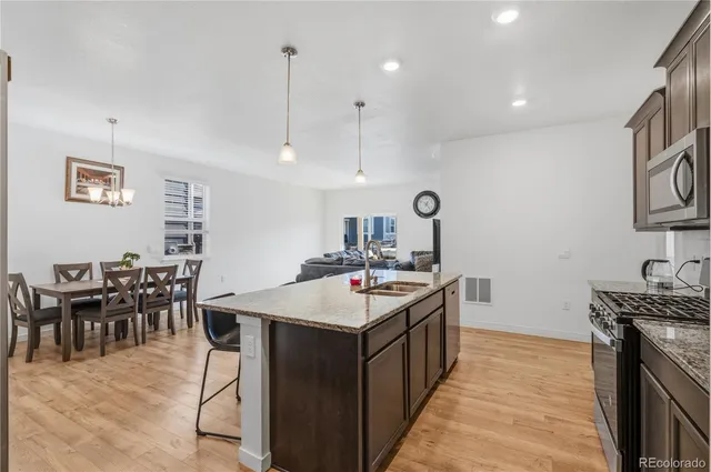 a kitchen with stainless steel appliances granite countertop a kitchen island a stove and a sink