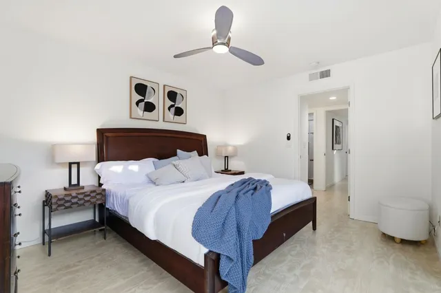 a bedroom with a bed and a painting on the wall