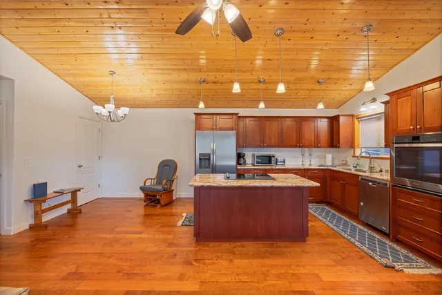 a bathroom with a granite countertop sink a large mirror and shower