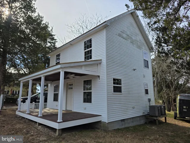 a view of house with a small yard and large tree