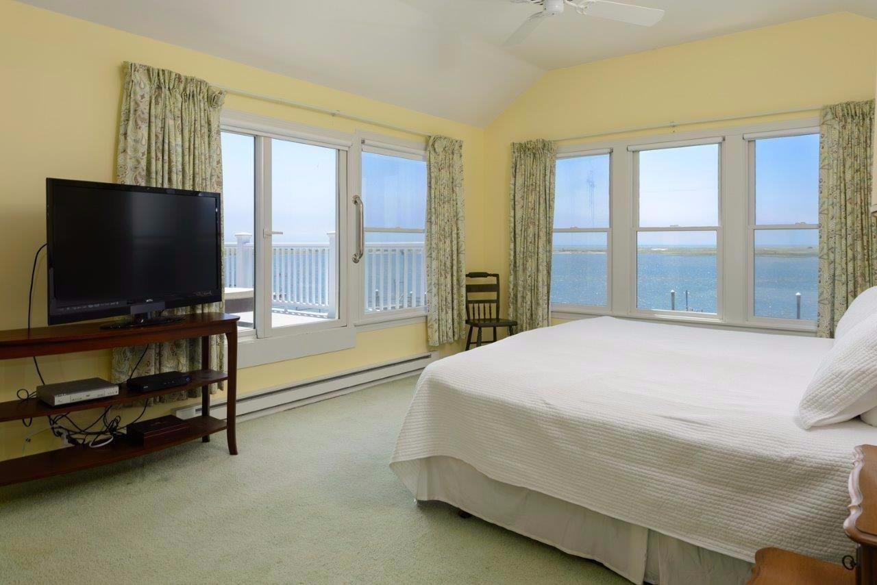 11 Riverside Way West Dennis, MA 02670 - Photo 16 of 25 a bedroom with a bed and a flat tv screen on dresser