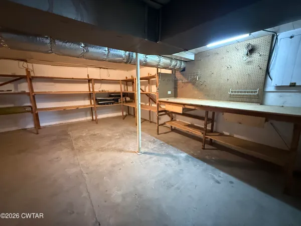a view of an empty room with wooden floor and windows
