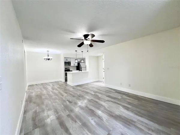a view of empty room with wooden floor and ceiling fan
