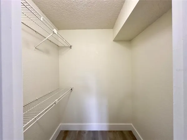 a view of walk in closet with empty racks