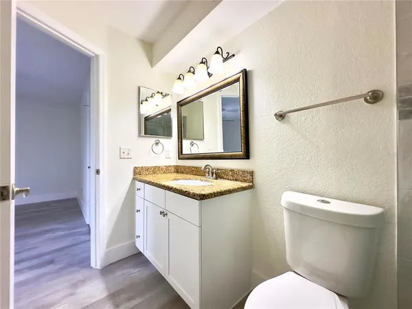 a bathroom with a granite countertop sink toilet and shower