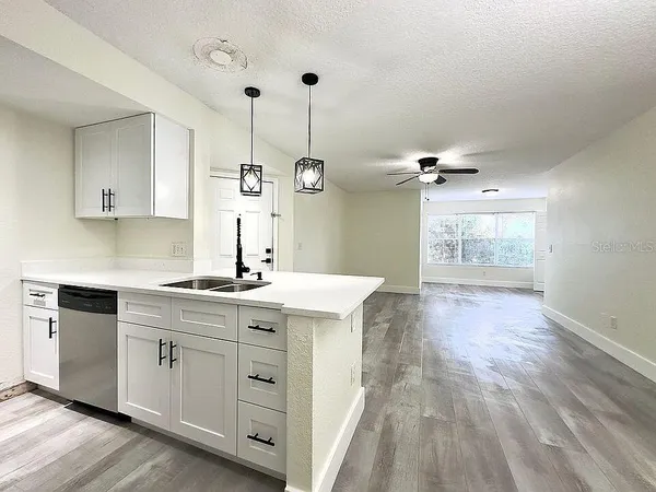 a kitchen with a sink cabinets and wooden floor