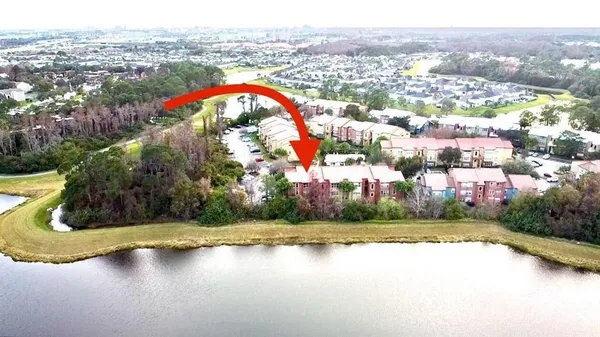 an aerial view of residential houses with outdoor space and lake view