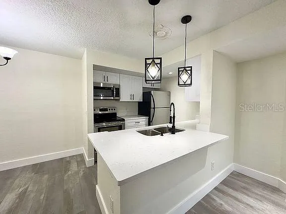 a kitchen with a sink a microwave and cabinets