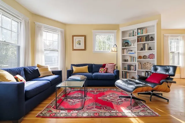 a living room with furniture a rug and a window