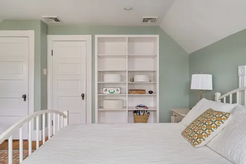 a bedroom with furniture and a book shelf