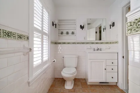 a bathroom with a toilet sink and mirror