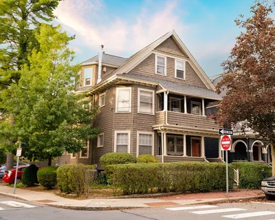 a front view of a house with a yard and potted plants