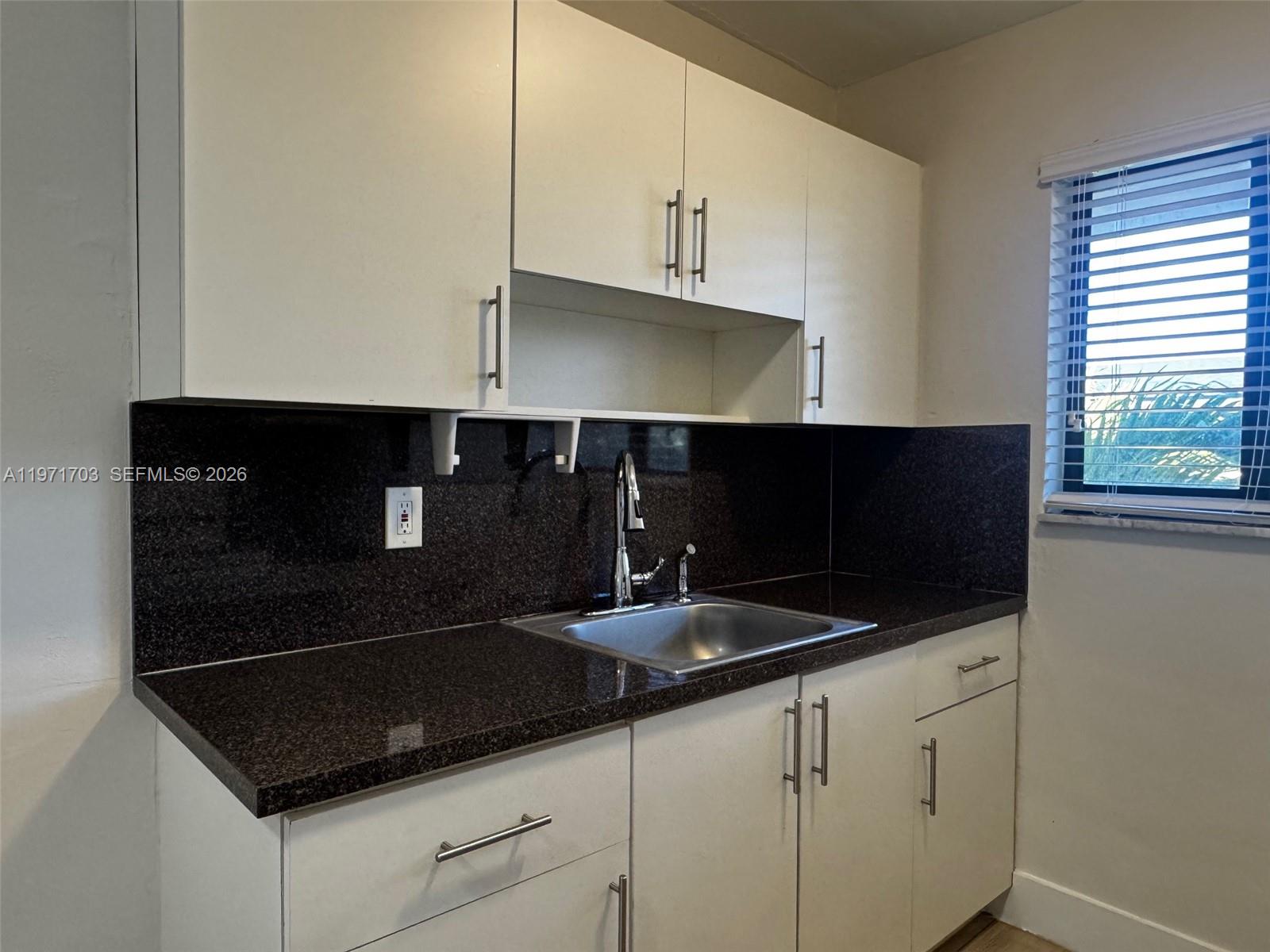 1330 West 29th Street, Unit 39 Hialeah, FL 33012 - Photo 11 of 17 a kitchen with granite countertop a sink and a stove