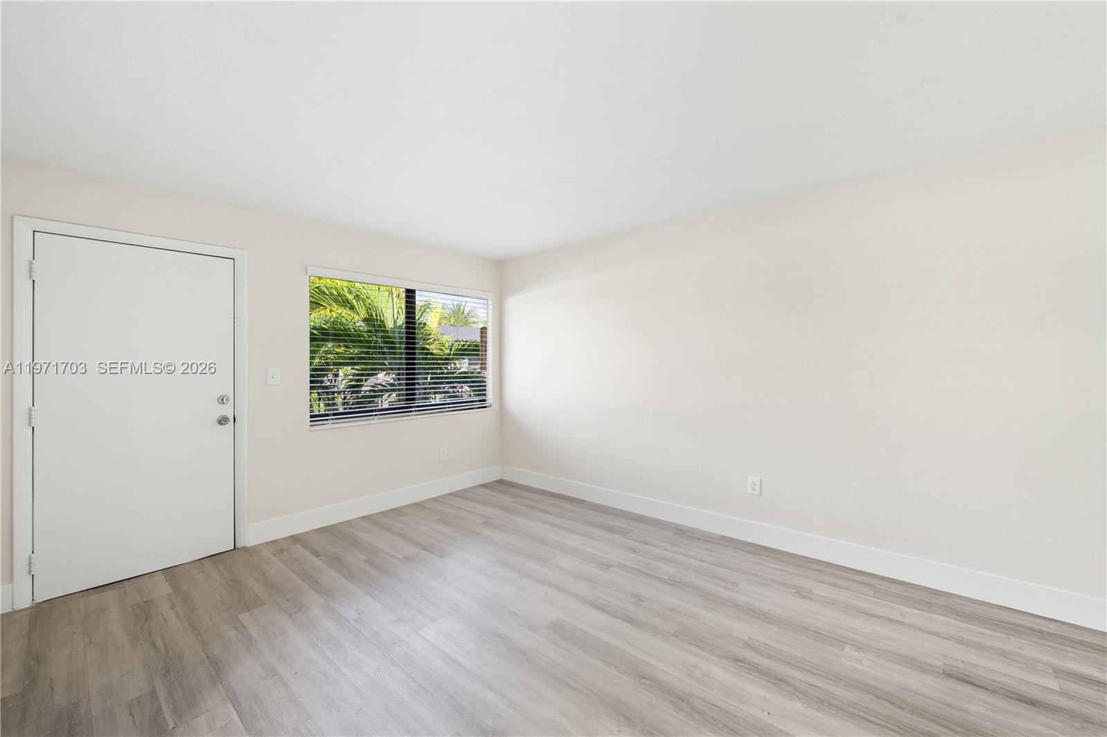 1330 West 29th Street, Unit 39 Hialeah, FL 33012 - Photo 8 of 17 an empty room with wooden floor and windows