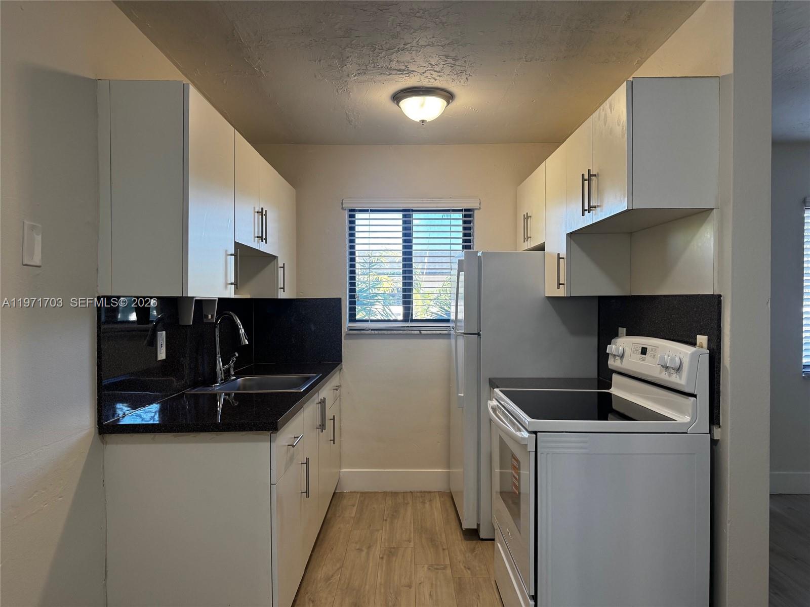 1330 West 29th Street, Unit 39 Hialeah, FL 33012 - Photo 10 of 17 a kitchen with stainless steel appliances a stove a sink and a refrigerator