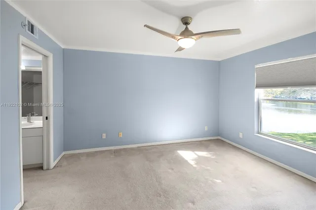 an empty room with a window and a fan