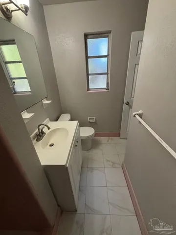 a bathroom with a sink a toilet and a mirror
