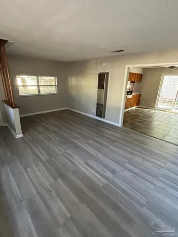 a view of empty room with wooden floor