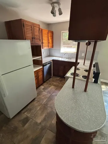 a kitchen with a refrigerator a sink and a stove
