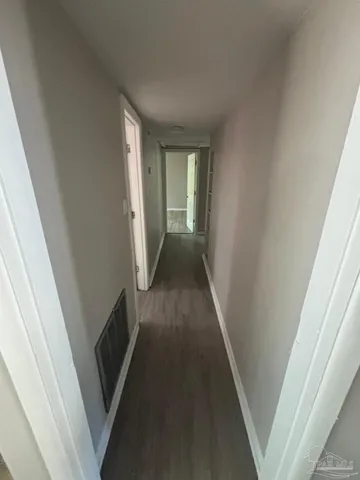 a view of a hallway with wooden floor and staircase