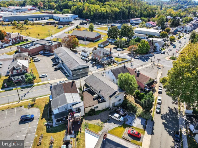 an aerial view of a house with swimming pool and outdoor seating