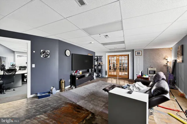a living room with furniture a flat screen tv and a large window