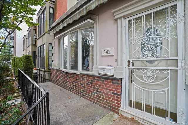 a front view of a building with glass door and stairs