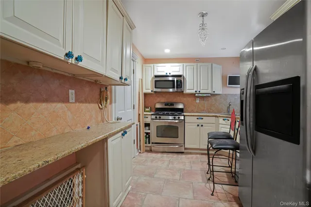 a kitchen with stainless steel appliances granite countertop a refrigerator sink and stove