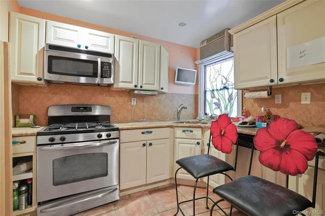 a kitchen with stainless steel appliances a stove microwave and cabinets