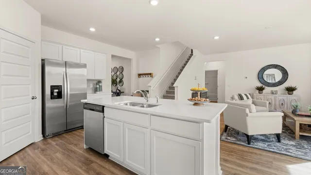 a kitchen with microwave a sink and chairs