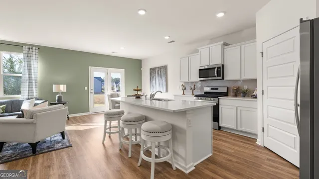 a kitchen with a dining table chairs refrigerator and microwave