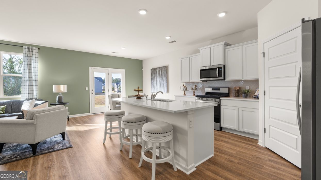 617 Lobelia Way Locust Grove, GA 30248 - Photo 12 of 44 a kitchen with microwave a sink and chairs