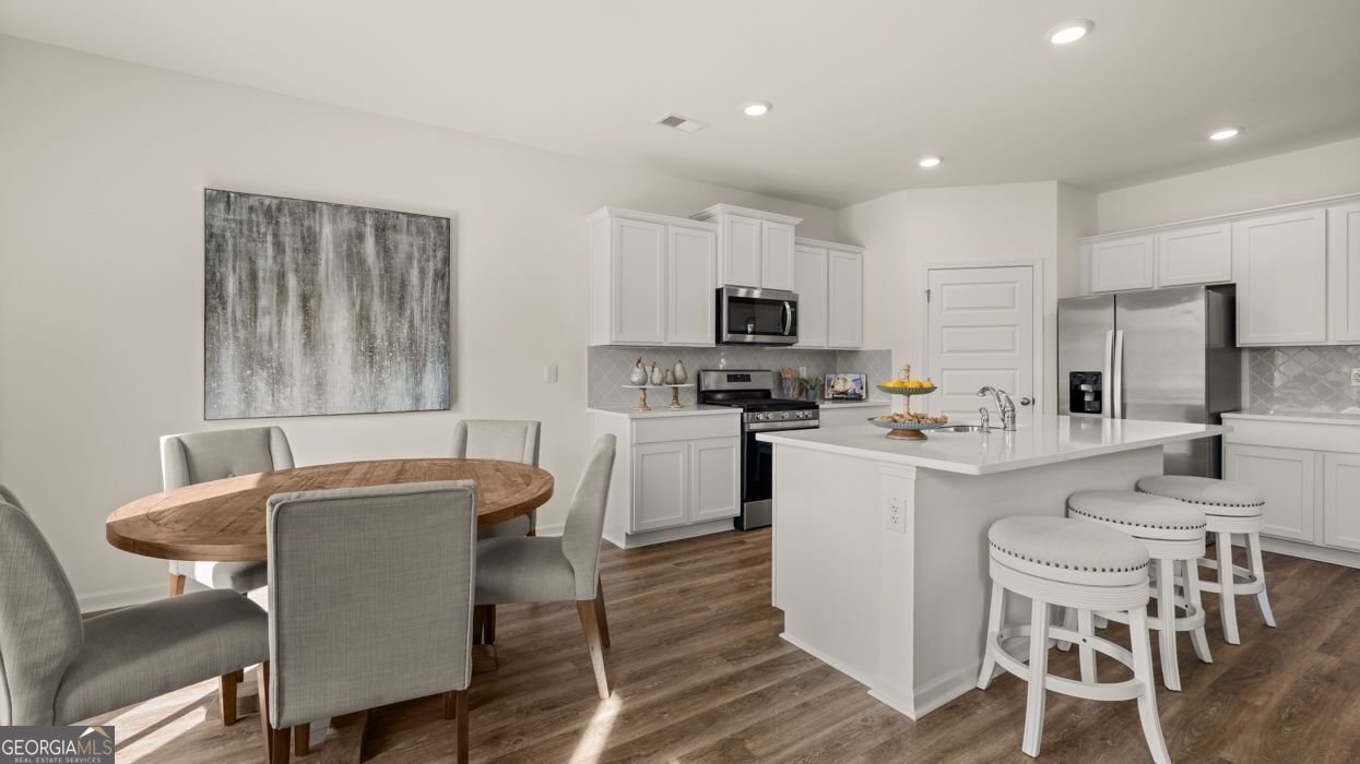 617 Lobelia Way Locust Grove, GA 30248 - Photo 14 of 44 a kitchen with table chairs microwave and cabinets